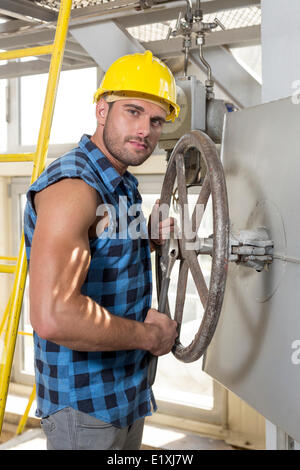 Porträt von überzeugt junge Arbeiter, die industriellen Ventil Befestigung Stockfoto