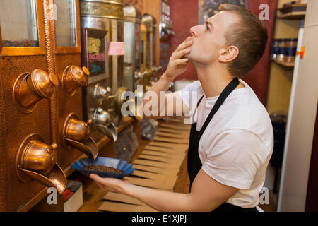 Seitenansicht des Verkäufers Verzicht auf Kaffeebohnen in Schüssel im store Stockfoto