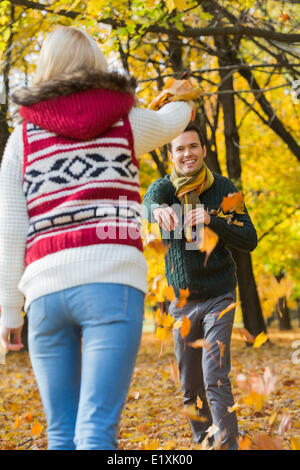 Glückliches junges Paar spielen mit Herbst Blätter im park Stockfoto