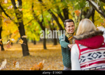 Glückliches Paar spielen mit Herbst Blätter im park Stockfoto