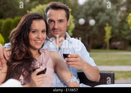 Porträt von schönen jungen Paar beim Rotwein im park Stockfoto