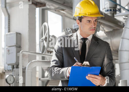 Jungen männlichen Vorgesetzten schreiben über Zwischenablage in der Industrie Stockfoto