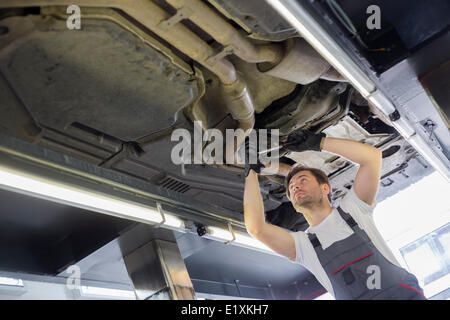 Niedrigen Winkel Blick auf männliche Automechaniker Auto Werkstatt Reparatur Stockfoto