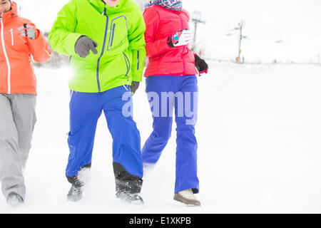 Drei junge Freunde laufen im Schnee Stockfoto