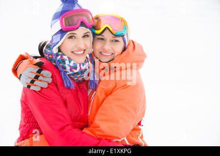 Porträt der glückliche junge Frauen in warme Kleidung umarmen im freien Stockfoto