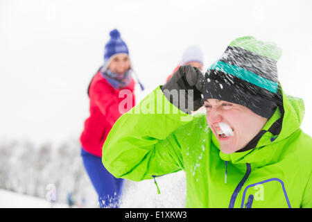 Junge Freunde, die Schneeball kämpfen Stockfoto