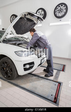 Voller Länge Seitenansicht des männlichen mechanische Reparatur Auto Automotor in Werkstatt Stockfoto