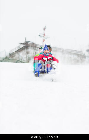 Gruppe von Freunden genießen Schlittenfahrt im Schnee Stockfoto