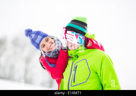 Lächelnde junge Frau mit den Augen des Mannes im winter Stockfoto