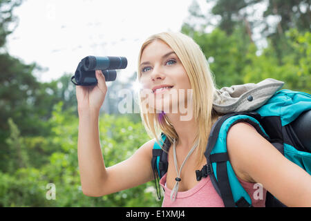 Junge weibliche Wanderer mit dem Fernglas im Wald Stockfoto