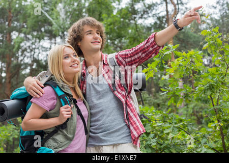 Junge männliche Wanderer zeigt etwas zu Frau im Wald Stockfoto