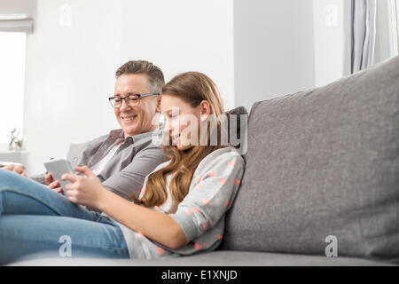 Vater und Tochter mit digital-Tablette zu Hause auf sofa Stockfoto