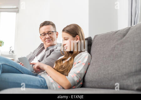 Vater und Tochter mit digital-Tablette zu Hause auf sofa Stockfoto