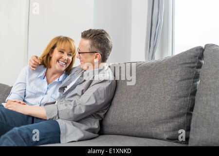 Glückliches Liebespaar sitzt zu Hause auf sofa Stockfoto