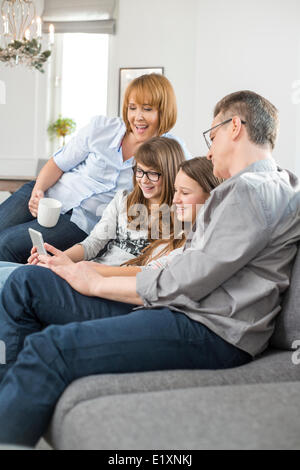 Fröhliche Familie mit Tablet-PC zu Hause auf sofa Stockfoto