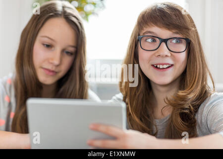Glückliches Mädchen mit Schwester mit digital-Tablette zu Hause Stockfoto