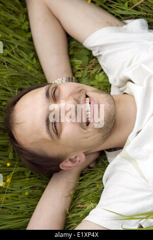 Der Mann auf einem Rasen sich erholend Stockfoto