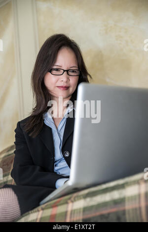Frau auf Sofa auf laptop Stockfoto