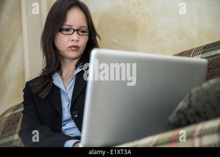 Frau auf Sofa auf laptop Stockfoto