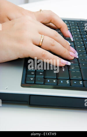 Frauenhand auf der Laptoptastatur Stockfoto