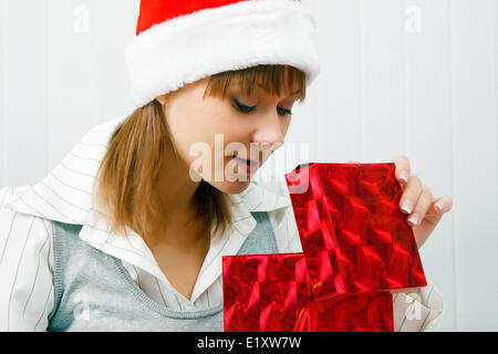 Attraktive Mädchen öffnet ein Weihnachtsgeschenk Stockfoto