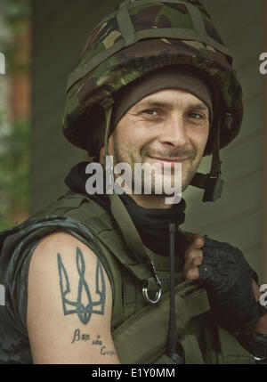 Donbas, Donezk, Ukraine. 10. Juni 2014. Soldat der Nationalgarde mit Dreizack - ukrainischen nationalen Symbol - Tattoo auf der Schulter Patrouillen an einem Kontrollpunkt in der Nähe von Slaviansk. Ukrainische Armee weiterhin die pro-russischen Terroristen unter Belagerung während ATO im Donbass. Die Militäroperation konzentriert sich zunehmend auf Slaviansk, einer Stadt mit 130.000, der seit April von maskierten, Tarnung verkleideten militanten schwingende Sturmgewehre und Granatwerfer gesteuert wurde, die zentrale Regel von Kiew zu widersetzen. Bildnachweis: Sergii Kharchenko/NurPhoto/ZUMAPRESS.com/Alamy Live-Nachrichten Stockfoto