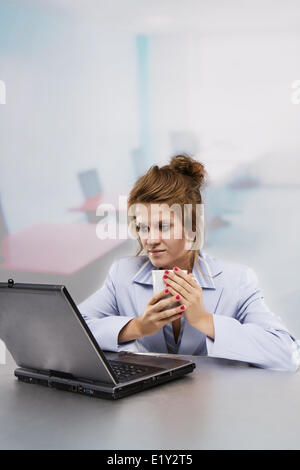 Frau mit Laptop, Kaffee trinken Stockfoto