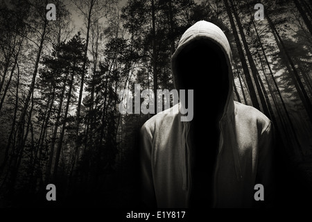 Porträt von gefährlicher Mann versteckt unter der Motorhaube im Wald Stockfoto