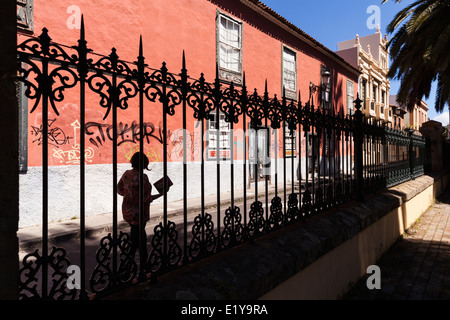 Schmiedeeiserne Geländer und Fußgänger von einem verfallenen alten Haus in San Cristobal De La Laguna, Teneriffa, Kanarische Inseln, Spanien Stockfoto