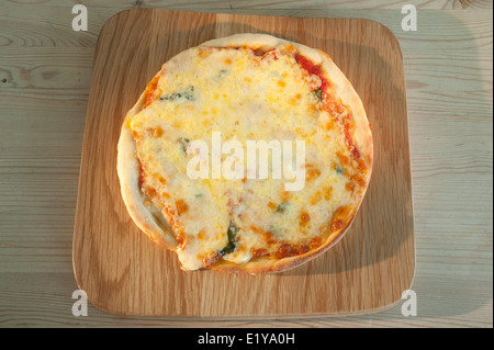 Tomate-Mozzarella und Basilikum Pizza auf einer Holzplatte. Stockfoto