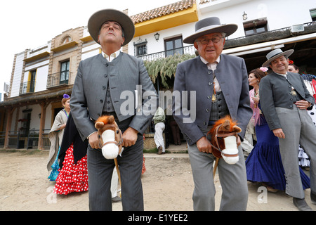 Rocio Romeria - Mann auf Steckenpferd Re-inszeniert Stierkampf mit anderen Männern während Frauen in traditionellen andalusischen Uhr auf Kostüm Stockfoto