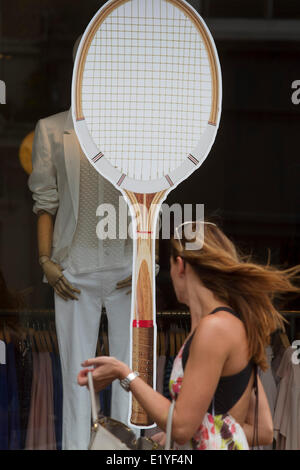 Wimbledon London, 11. Juni 2014. Ein Fußgänger geht vorbei an einem Tennisschläger in einem Fenster als Geschäfte und Restaurants schmücken Fenster mit Tennis-Themen in der Flucht, die 2014 Lawn-Tennis Championships in Wimbledon Credit: Amer Ghazzal/Alamy Live-Nachrichten Stockfoto