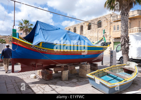 Hölzerne Angelboot/Fischerboot geschleppt bis auf Kai im Hafen von Marsaxlokk, Malta, Stockfoto