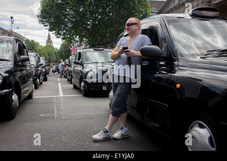 Schwarzes Taxi Taxifahrer protestieren in Whitehall, London und Einspruch gegen eine neue Online-Buchung und Reise-Tarif app namens Uber. Die app funktioniert die Kosten für Fahrten und Taxifahrer sagen, es ist das gleiche wie mit ein Taxameter, welche nur Taxis gesetzlich berechtigt sind, zu benutzen. Das London Taxi Fahrer Association (LTDA) sagte auch Teil der Demo war über die Dauer der Ausbildung - zwischen vier und sieben Jahren Hervorhebung - Taxifahrer zu unterziehen, bevor zugelassen. Während des Protestes wurden Straßen rund um Whitehall, Parliament Square und Trafalgar Square in der Hauptstadt West End festgefahrene. Stockfoto