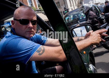 Schwarzes Taxi Taxifahrer protestieren in Whitehall, London und Einspruch gegen eine neue Online-Buchung und Reise-Tarif app namens Uber. Die app funktioniert die Kosten für Fahrten und Taxifahrer sagen, es ist das gleiche wie mit ein Taxameter, welche nur Taxis gesetzlich berechtigt sind, zu benutzen. Das London Taxi Fahrer Association (LTDA) sagte auch Teil der Demo war über die Dauer der Ausbildung - zwischen vier und sieben Jahren Hervorhebung - Taxifahrer zu unterziehen, bevor zugelassen. Während des Protestes wurden Straßen rund um Whitehall, Parliament Square und Trafalgar Square in der Hauptstadt West End festgefahrene. Stockfoto