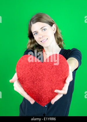 Nette junge Frau hält ein Herz Stockfoto
