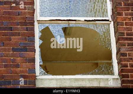 zerbrochenes Fenster in einem verlassenen sechziger Jahren zerschlagen Bürogebäude England UK Stockfoto