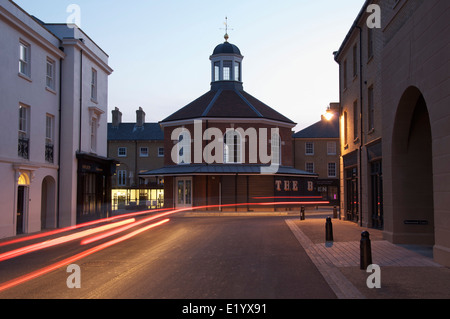 Verkehrssysteme. Prinz Charles' Experiment in der modernen Stadtplanung. Autoscheinwerfer Streifen nach dem Buttercross Square. Dorset, England, Vereinigtes Königreich. Stockfoto