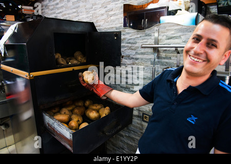 Kumpir (eine Mega große Ofenkartoffel gefüllt mit vielen leckeren Füllungen) Kartoffel ist eine sehr beliebte street Food in Ortakoy, Istanbul Stockfoto