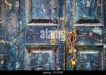 Alte blaue Holztür mit Vorhängeschlössern Stockfoto