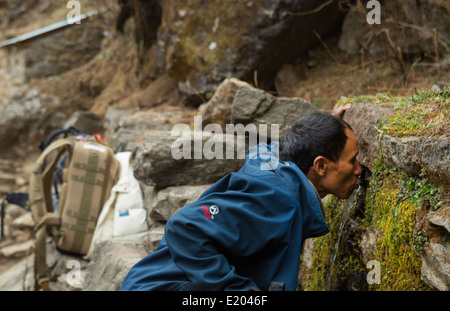 Nepal Nepali Mann trinkt aus öffentlichen Brunnen entlang in Solukhumbu remote in der Nähe von Mt Everest 50 Stockfoto