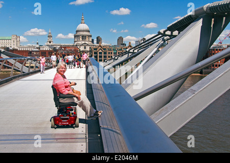 Mobilität Roller und Reiter auf die Millennium Bridge über die Themse Stockfoto