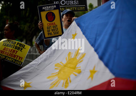 Makati, Philippinen. 12. Juni 2014. Demonstranten halten die philippinischen Nationalflagge während einer Protestaktion vor dem chinesischen Konsulat in Makati, Metro Manila, Philippinen, 12. Juni 2014. Demonstranten geprägt Independence Day in den Philippinen hielt einen Protest gegen China angebliche Mobbing über einen territorialen Streit mit den Philippinen und in Vietnam in der South China Sea.Photo: Ezra Acayan/NurPhoto Credit: Ezra Acayan/NurPhoto/ZUMAPRESS.com/Alamy Live News Stockfoto