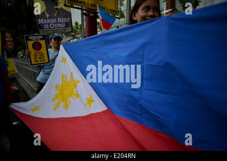 Makati, Philippinen. 12. Juni 2014. Demonstranten halten die philippinischen Nationalflagge während einer Protestaktion vor dem chinesischen Konsulat in Makati, Metro Manila, Philippinen, 12. Juni 2014. Demonstranten geprägt Independence Day in den Philippinen hielt einen Protest gegen China angebliche Mobbing über einen territorialen Streit mit den Philippinen und in Vietnam in der South China Sea.Photo: Ezra Acayan/NurPhoto Credit: Ezra Acayan/NurPhoto/ZUMAPRESS.com/Alamy Live News Stockfoto