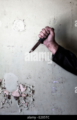 eine männliche Hand mit einem rostigen Messer Stockfoto