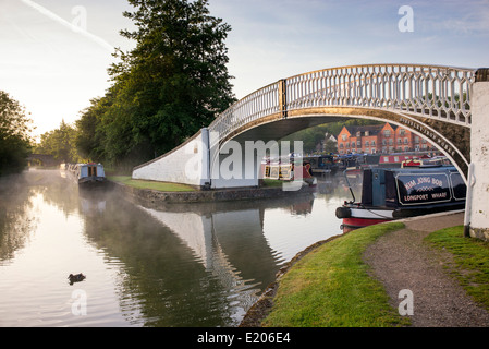 Narrowboats und Bügeleisen Fußgängerbrücke in Braunston Marina auf dem Grand Union Canal. Braunston, Northamptonshire, England Stockfoto