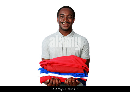 Porträt eines fröhlichen afrikanischen Mannes hält seine Kleider auf weißem Hintergrund Stockfoto