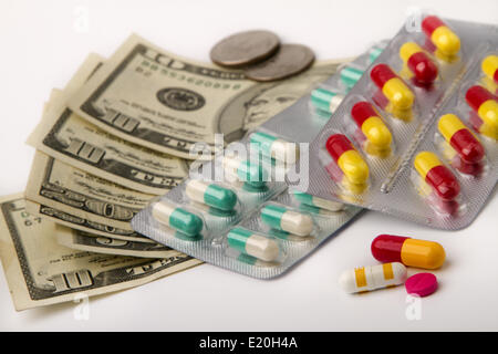 Tabletten in Rudeln gegen Dollar-Banknoten Stockfoto