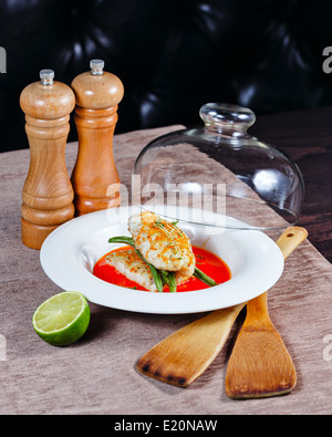 Filet vom Barsch mit Gemüse und Soße serviert auf einem weißen Teller in einem restaurant Stockfoto