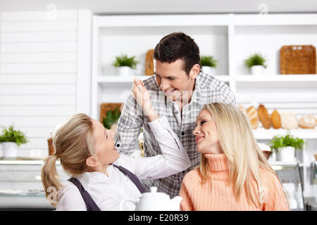 Zwei Mädchen und der Mann viel Spaß im café Stockfoto